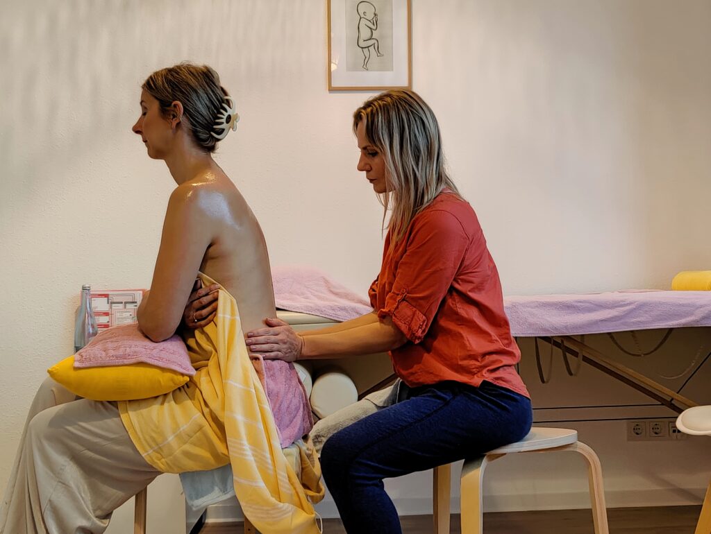 Carina Welzel führt eine Therapeutische Frauenmassage (TFM) am Rücken einer Frau durch – Frauenwohl & Babyglück Bochum.
