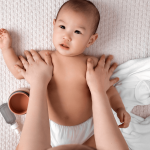 Babymassage Brust Baby liegt entspannt auf dem Rücken, die Brust wird sanft massiert – Babymassage bei Frauenwohl & Babyglück Bochum.